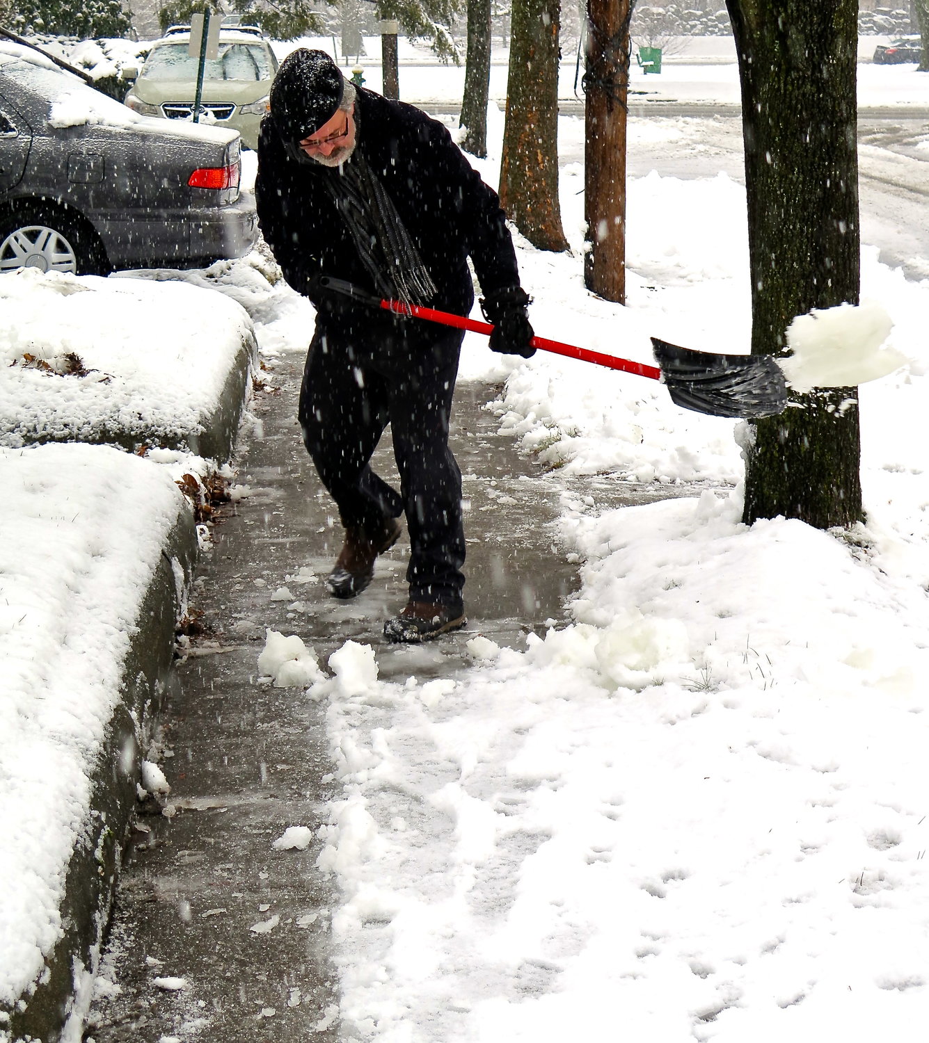 Tom Schmeling clears the walk of someone who couldn't after a big snow storm